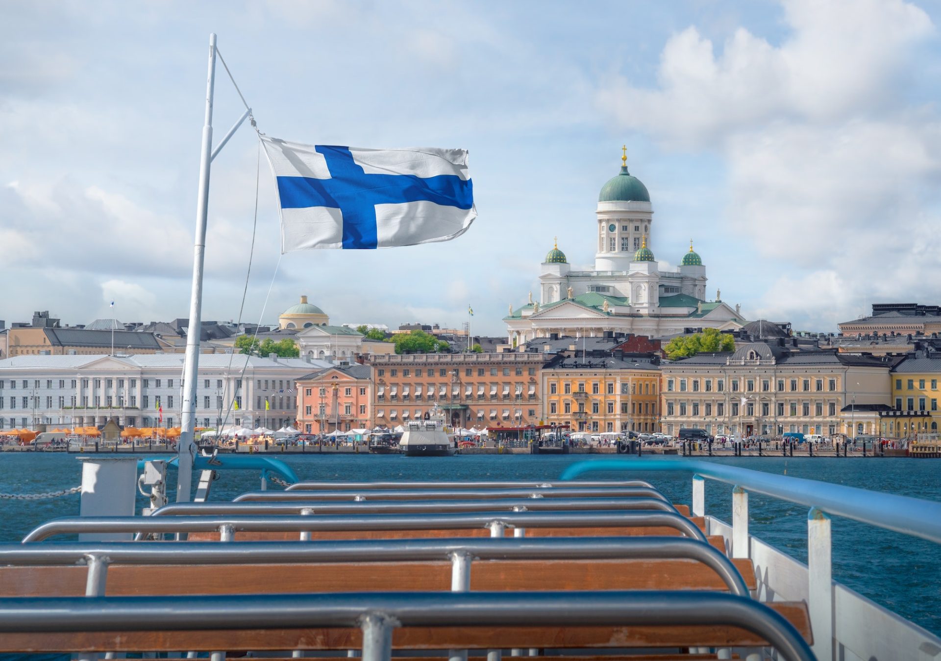 Helsinki skyline boat view with Finnish flag and Helsinki Cathedral - Helsinki, Finland